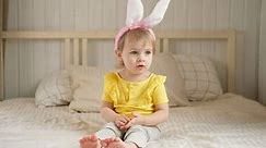 Portrait of adorable baby girl with bunny ears. Cute funny girl celebrating Easter at home. Surprised little kid. Spring. Traditional symbol of holiday and religion concept. Happy Easter. Easter child