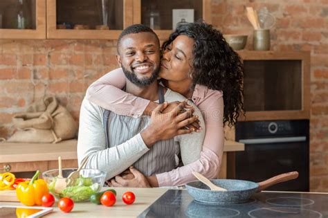 Portrait Of Lovely Black Couple Embracing At Kitchen Stock Image