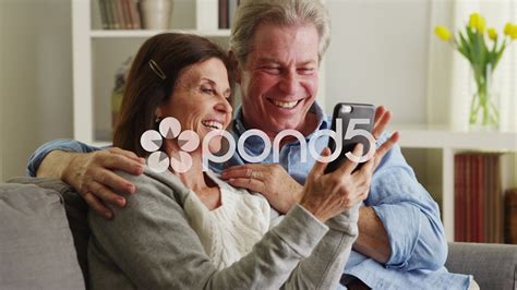 Sweet Senior Couple Using Smartphone On Couch Stock Footagecoupleseniorsweetsmartphone