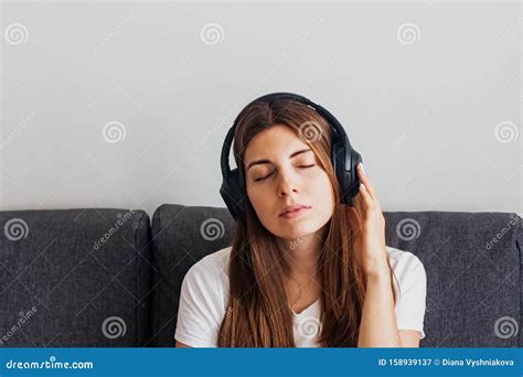 Young Woman Inheadphones Listening To Calm Music And Relaxing At Home