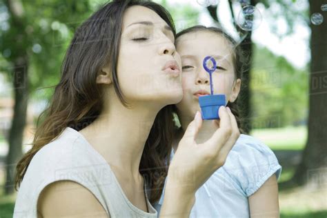 Girl And Mother Blowing Bubbles Together Stock Photo Dissolve