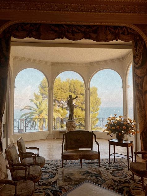 A Living Room With Large Arched Windows Overlooking The Ocean And