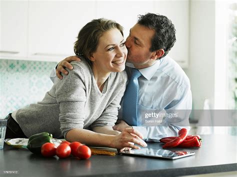 Businessman Kissing Wife In Kitchen Photo Getty Images