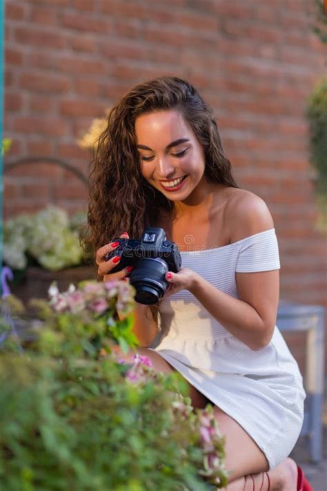 Young Attractive Female Student Or Tourist Using A Mirrorless Camera