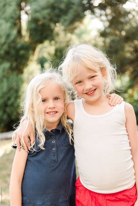 Two Little Blonde Girls Hugging By Stocksy Contributor Lea Jones