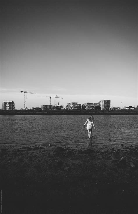 "Woman Goes Into Urban River" by Stocksy Contributor "Urs Siedentop