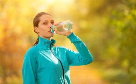 Young Woman Drinking Fresh Water During Her Fitness Exercise Stock