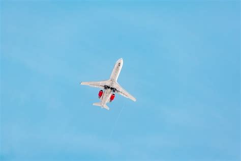 Um avião a jato está voando no céu ao pôr do sol Foto Premium