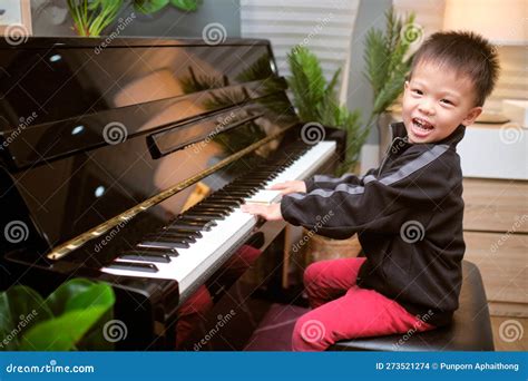 Cute Happy Smiling Little Asian Kid Boy Playing Piano In Living Room