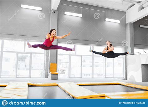 Young Active Women Jumping On Trampolines In A Modern Fitness Center