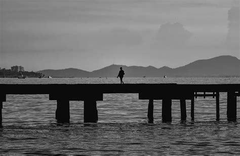 Silhouette Man Standing On Pier Over Sea Id 148431600