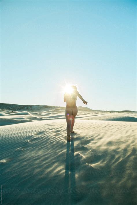 A Naked Woman Running Across Sand Towards The Sun Del Colaborador De
