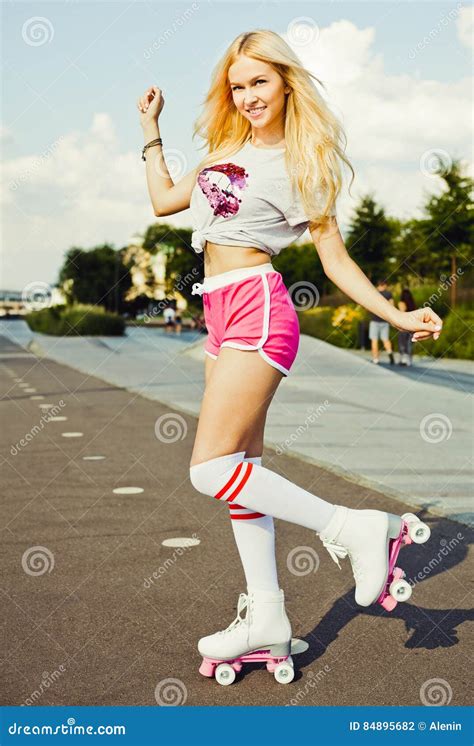 Beautiful Blonde Girl Posing On A Vintage Roller Skates In Pink Shorts