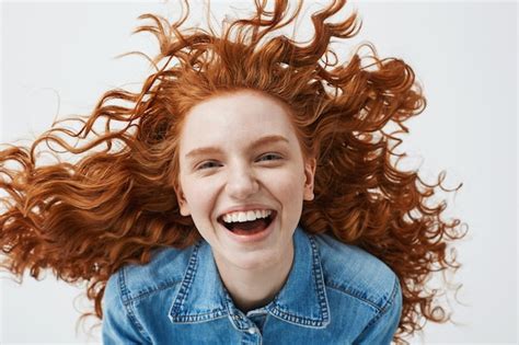 free photo cheerful redhead woman with flying curly hair smiling laughing
