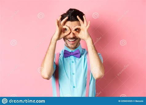 Cheerful Man In Bow Tie And Suspenders Looking Through Hand Binoculars And Smiling Seeing