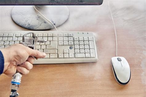 Premium Photo Employee Cleans Dusty Keyboard And Dusty Desk With Air