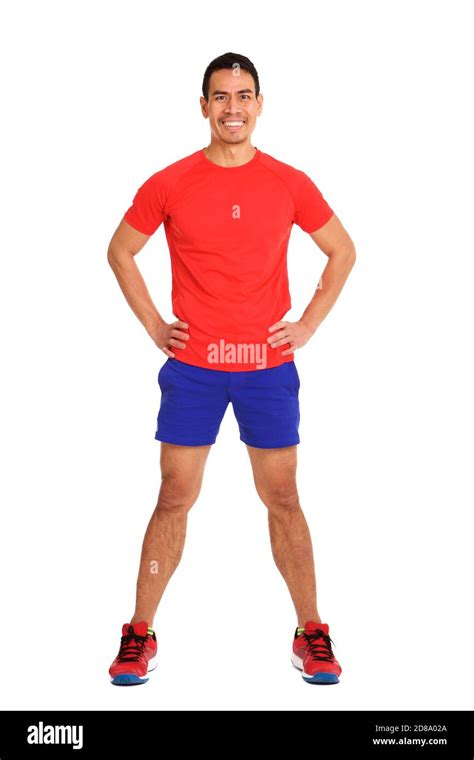 full body portrait of fit mature asian man in sportswear standing with hands on hips over white