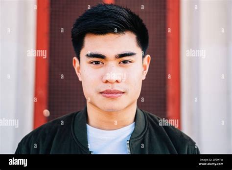 Portrait Of Serious Asian Guy Looking At Camera Outdoors Stock Photo