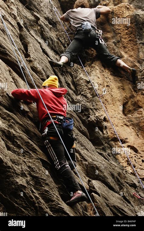 Two Rock Climbers Scaling A Near Vertical Cliff Wall In Nepal Stock