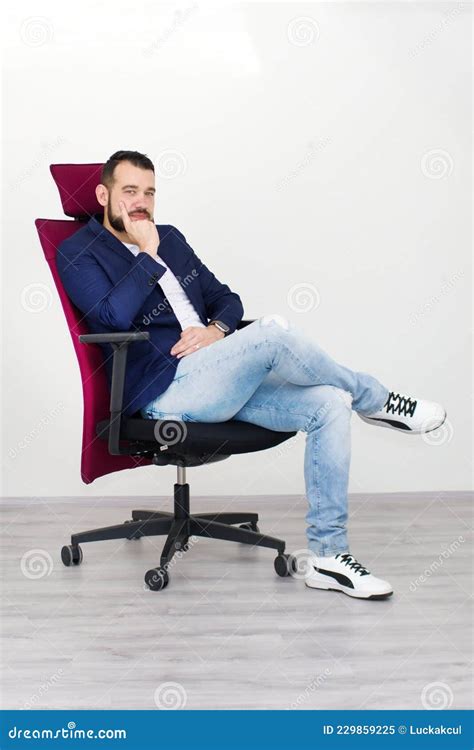 Young Man Sitting On Office Chair And Smiling Working Photo From The