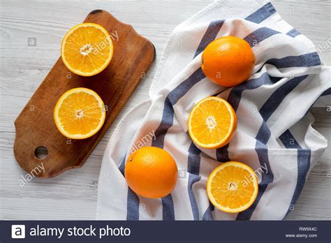 Halved And Whole Oranges On White Wooden Background Top View Overhead
