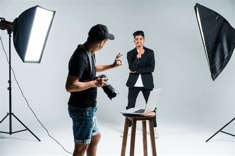Professional Young Photographer Taking Photos Of Indian Model In Studio