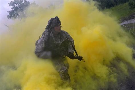 a soldier runs through smoke to return to cover after placing a simulated explosive charge on an