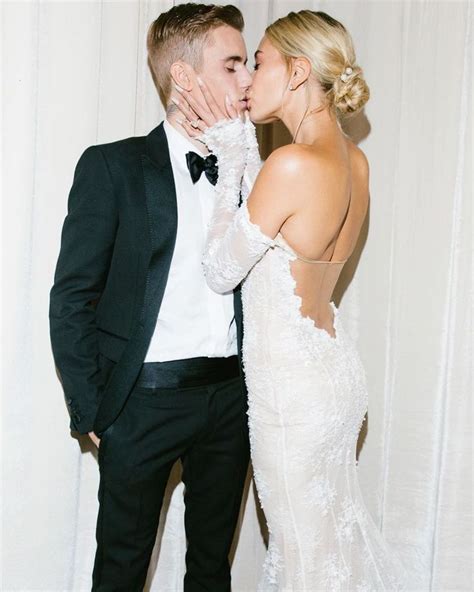 A Man In A Tuxedo Kissing A Woman In A Wedding Dress