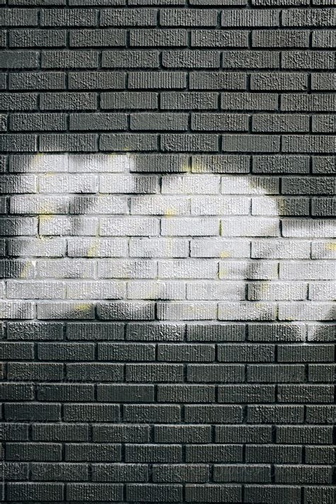 Metallic Silver Spray Paint Covering Graffiti Tags On Brick Wall By