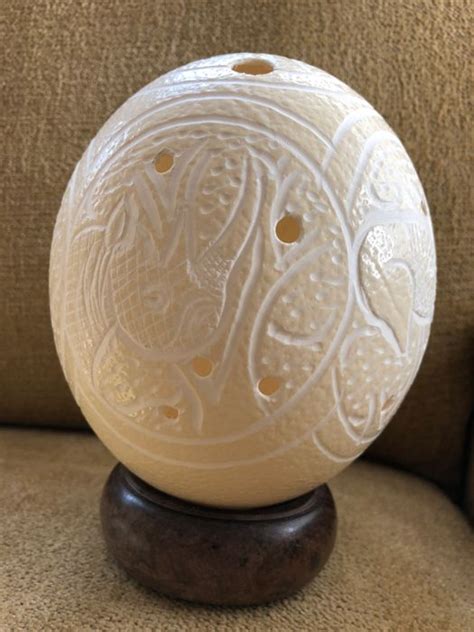 Blue marvel ostrich egg is carved to form intricate symmetrical patterns on both sides and lined with silver cord. Richly decorated African Ostrich Egg - Catawiki