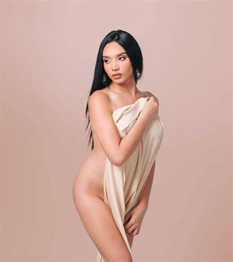 An Image Of A Woman Posing Naked In A Tan Dress With Her Arms On Her Hips