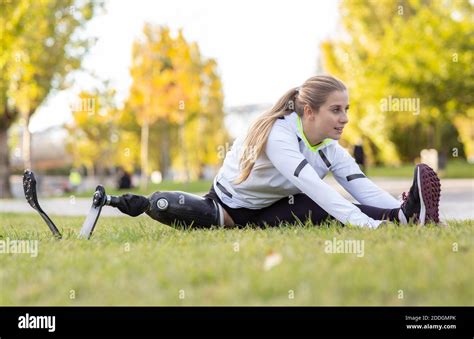 Professional Female Sportswoman With Artificial Limb Sitting On Grass
