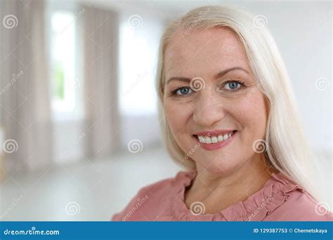 Portrait Of Beautiful Older Woman Against Blurred Background Stock