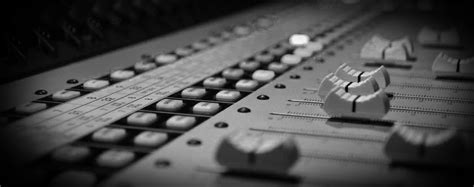 Musician at the mixer, professional music mixing. recording-studio-mixing-board-faders1 - Monocroma