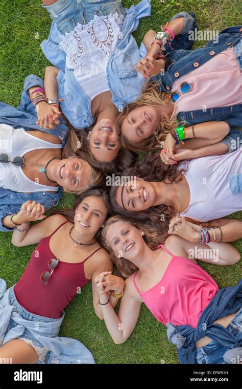 Happy Teen Girls In Circle Holding Hands And Smiling Stock Photo