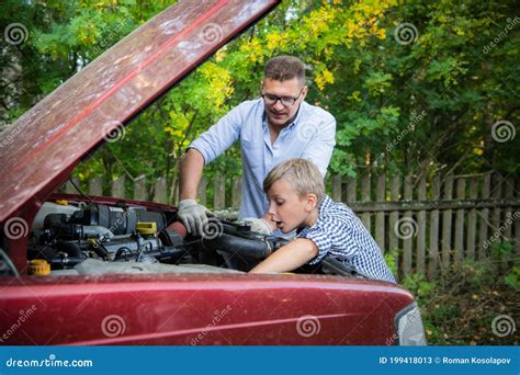 El Padre Y El Hijo Revisando El Motor Del Coche Imagen De Archivo