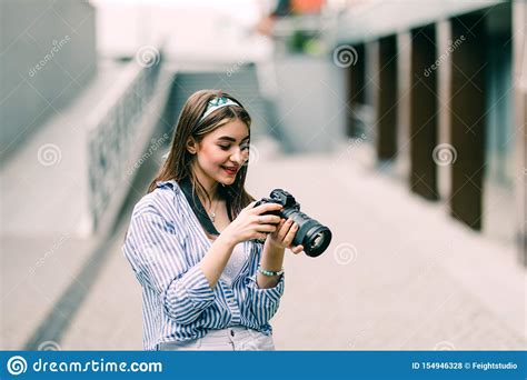 Happy Young Woman On Vacation Photographing With Camera On The City