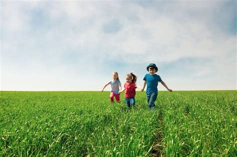 Niños Felices De Niños Y Niñas Corren En El Parque Sobre La Hierba En