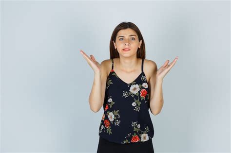 free photo attractive lady in blouse showing helpless gesture and looking confused front view