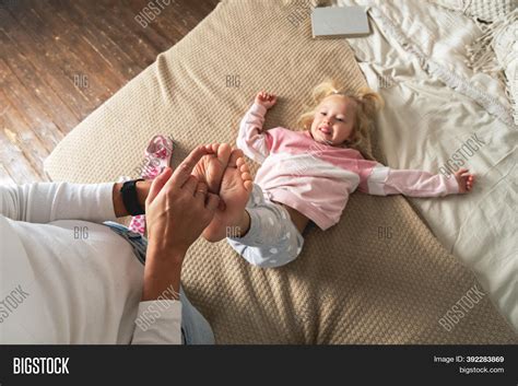 mom tickles her little image and photo free trial bigstock