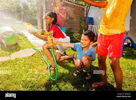 Group Of Kids Play Water Gun Fight Game Outside Stock Photo Alamy