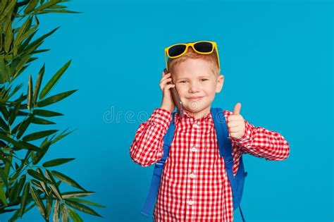 Little Hipster Boy With Backpack And Sunglasses Holding Telephone And