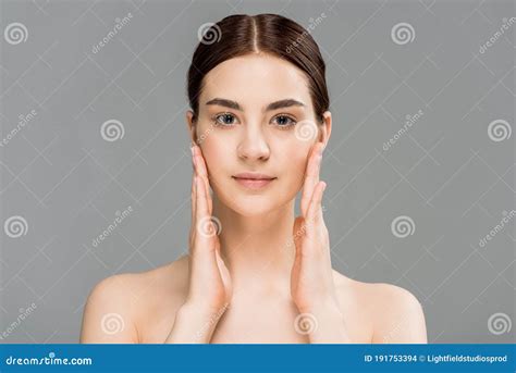 Naked Woman Looking At Camera And Touching Face Isolated On Grey Stock