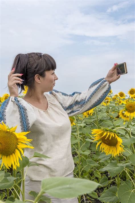 A Beautiful Dark Haired Ukrainian Woman Years Old In A Field Among Sunflowers Takes A