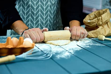 Baker Hands Preparing Fresh Dough With Rolling Pin On Kitchen Table