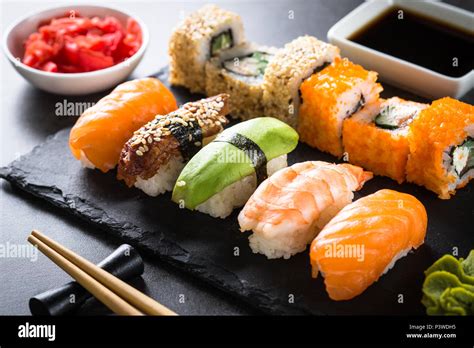 Sushi And Sushi Roll Set On Black Stone Table Traditional Asian Food
