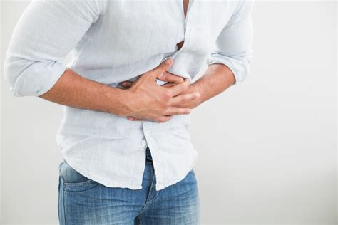 Close Up Mid Section Of A Young Man Suffering From Stomach Pain Against