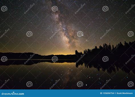 A Starry Brilliant Milky Way Spills Over A Lake Stock Photo Image