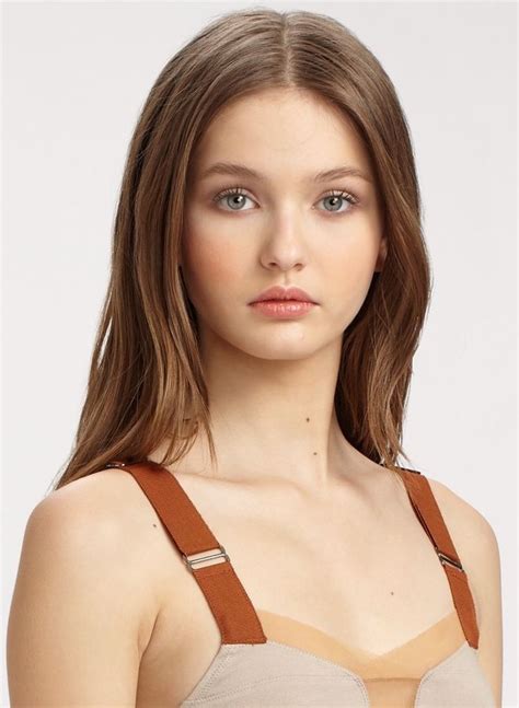 A Woman Wearing A Tan Bra And Brown Suspenders