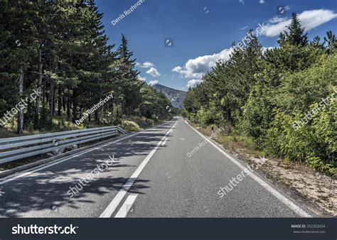 Country Road Through Rocky Mountains Forest Stock Photo 762352654